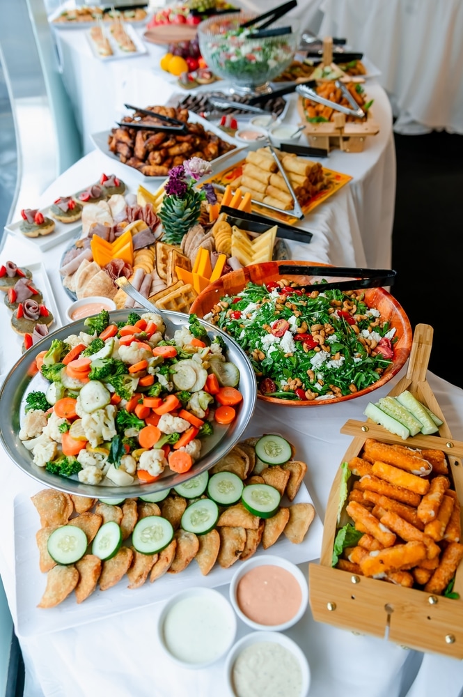 Buffet traiteur : sélection d'entrées, charcuterie et salades. Buffet d'entrées variées : charcuterie, salade verte, légumes vapeur, empanadas et bâtonnets de mozzarella frits.